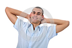 Smiling young man with hands behind head isolated