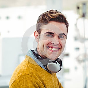 Smiling young man with headphones working in modern office environment photo