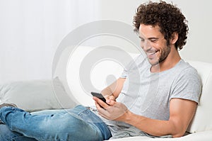 Smiling Young Man Holding Cellphone photo