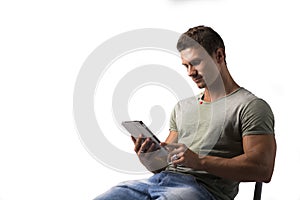 Smiling young man holding ebook reader, sitting