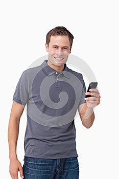 Smiling young man holding his cellphone