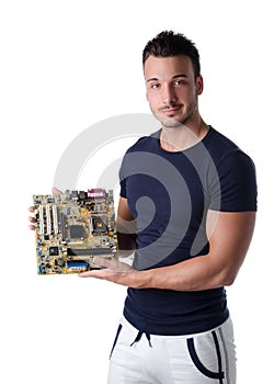 Smiling young man holding and showing computer motherboard