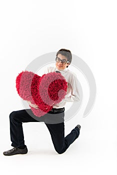 Smiling young man holds a red heart