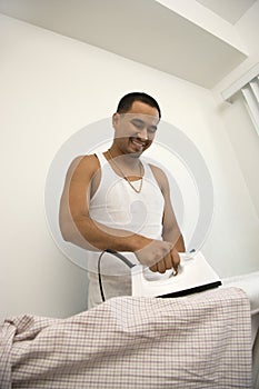 Smiling Young Man Ironing