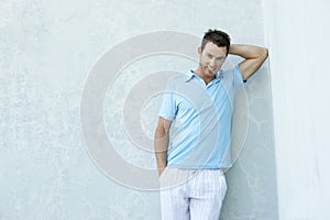 Smiling Young Man Leaning Against Wall