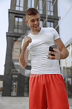 Smiling young man looking at his smartphone