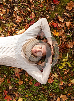 Smiling young man lying on ground in autumn park