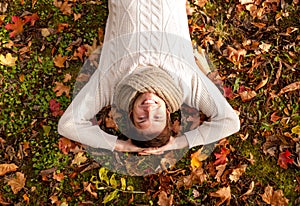 Smiling young man lying on ground in autumn park