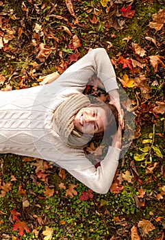 Smiling young man lying on ground in autumn park