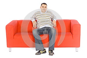 Giovane uomo sul arancia divano 