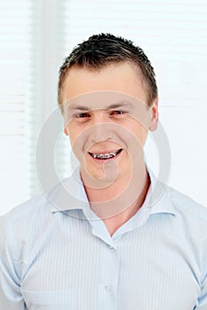 Smiling young man with orthodontic braces.