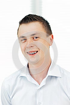 Smiling young man with orthodontic braces.