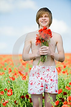 Smiling young man with poppies
