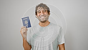 Smiling young man proudly holding his united states passport, radiating joy and confidence against isolated white background