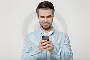 Smiling young man reading pleasant message from beloved woman.