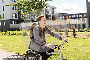 Smiling young man riding bicycle on city street