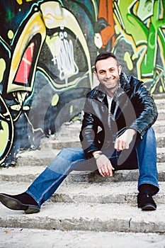 Smiling young man sitting on the stairs