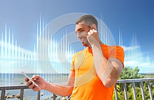 Smiling young man with smartphone and earphones