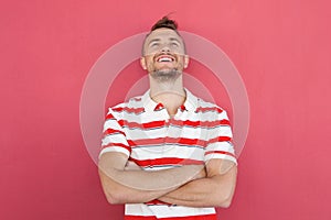 Smiling young man standing against red wall looking up