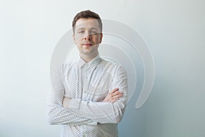 Smiling young man standing with arms crossed