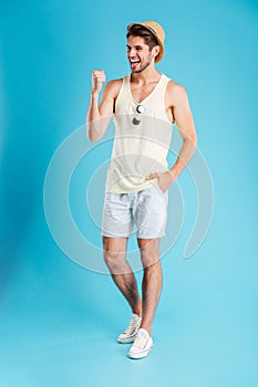 Smiling young man standing and celebrating success