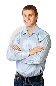 Smiling young man standing with his arms folded