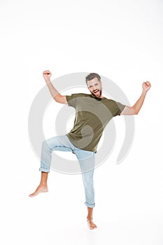 Smiling young man standing isolated over white background.