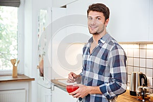 Smiling young man standing on the kitchen