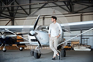 Smiling young man standing near small aircraft