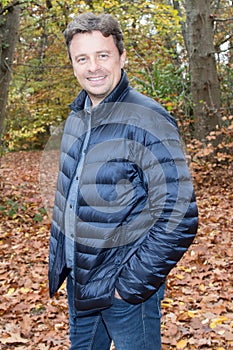 Smiling young man standing near the tree