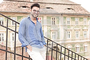 Smiling young man standing on some city stairs