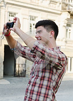 Smiling young man taking a photograph