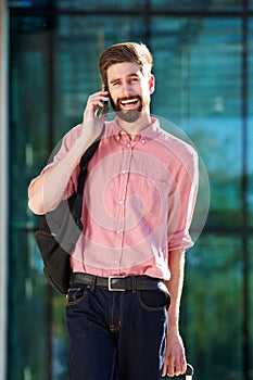 Smiling young man talking on mobile phone in city