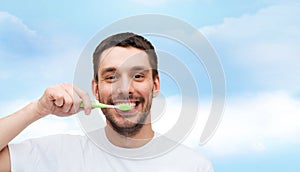 Smiling young man with toothbrush