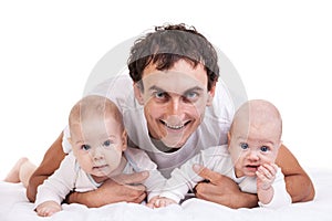 Smiling young man with two baby boys over white