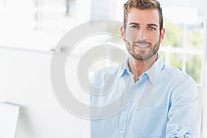 Smiling young man using computer in office