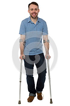 Smiling young man using crutches