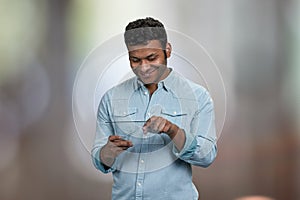 Smiling young man using transparent digital tablet.