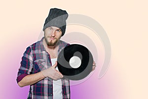 Smiling young man with vinil isolated on colorful background photo