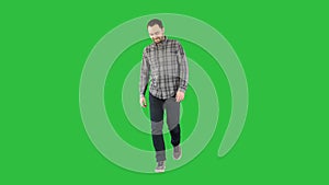 Smiling young man is walking on a Green Screen, Chroma Key.