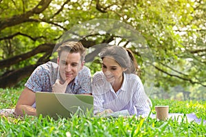 smiling young man and woman couple using computer to searching for information for weddings, honeymoon travel, insurance and home