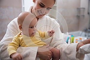 Smiling young mother in the bathroom with child stock photo
