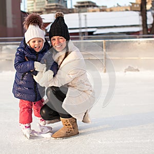 Smiling young mother and her cute little daughter