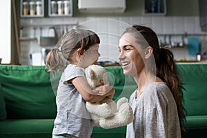 Smiling young mum talking with little daughter