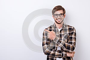 Smiling young nerdy bearded stylish student is standing on pure