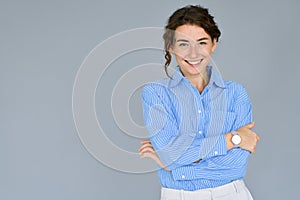 Smiling young pretty professional business woman at gray background portrait.