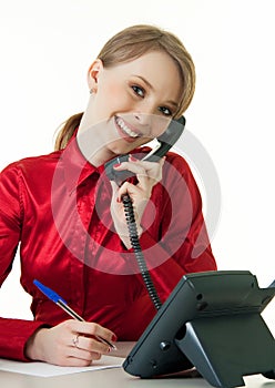 Smiling young receptionist using desk phone