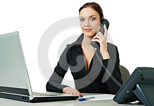 Smiling young receptionist using desk phone