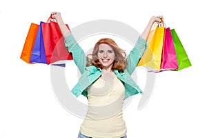 Smiling young redhead girl colorful shoppingbags photo
