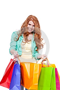 Smiling young redhead girl with colorful shoppingbags photo
